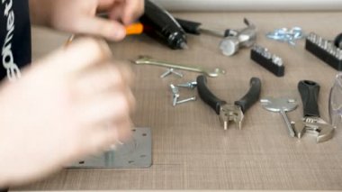 Adam metal bir plaka işaretleri ve vidalar sabitleyen vidayı yerleştirerek eller