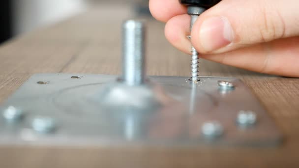 Montage einer Schraube im Tisch durch eine Metallplatte — Stockvideo