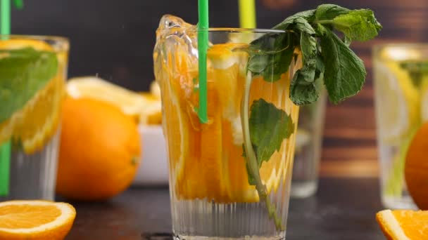 Soplando burbujas en un vaso con agua con vitaminas y rebanadas de oratos — Vídeos de Stock