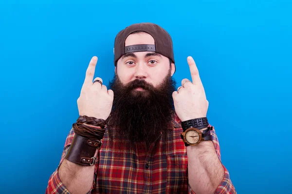 Hipster homem com barba longa apontando para cima com as duas mãos — Fotografia de Stock