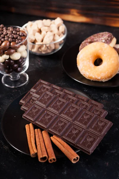 Tablet çikolatalar, çörek, kahverengi şeker çikolata ve kahve fasulye fıstık ile Üstten Görünüm — Stok fotoğraf