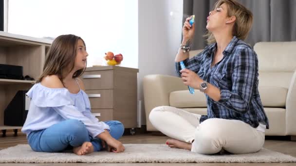 Мать пускает мыльные пузыри в свою дочь-подростка — стоковое видео
