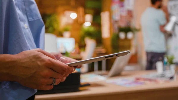 Manos de mujer sosteniendo una tableta digital en el espacio creativo — Foto de Stock