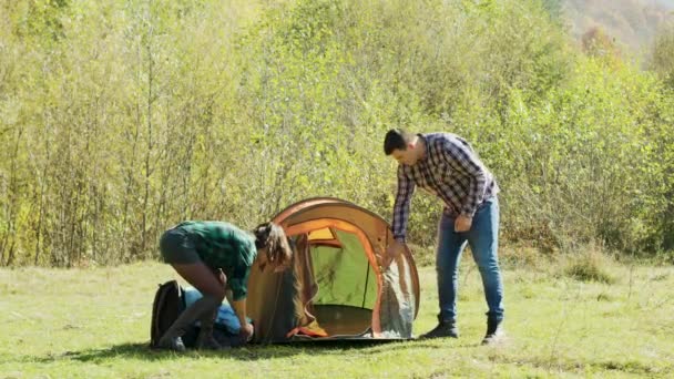 Vacker fru hjälper sin man att sätta tältet — Stockvideo