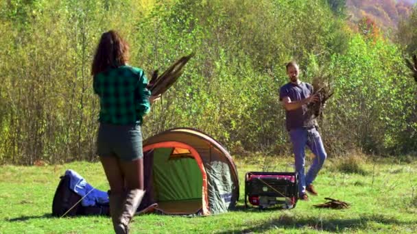 Arkadaşlar gece çökmeden kamp ateşi yakmaya hazırlanıyorlar. — Stok video