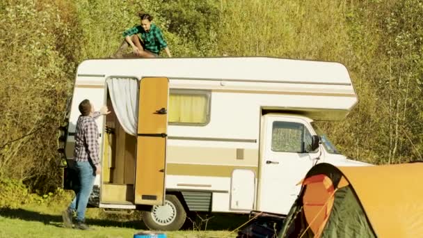 Jeune femme se détendre sur le dessus de camping-car vintage — Video