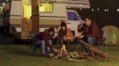 Kamp ateşini yakmaya yardım eden bir çiftin arkadaşı.