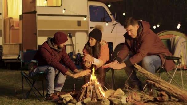 Nära vän sitter på campingstolar runt lägereld — Stockvideo