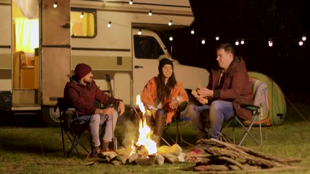 Gruppe enger Freunde lacht gemeinsam am Lagerfeuer — Stockvideo