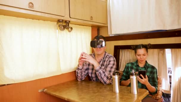 Young man with vr goggles inside of retro camper van — Stockvideo