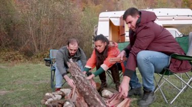 Çift ve yakın arkadaşları kamp ateşi hazırlıyor.