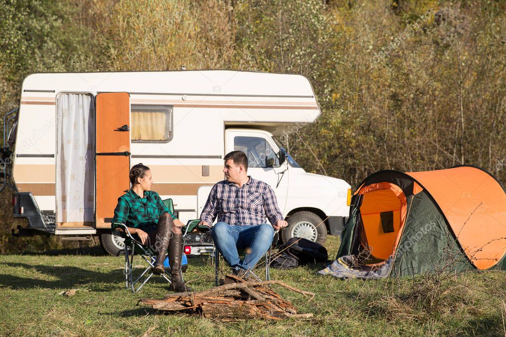 Couple relaxing together in campsite in the mountains