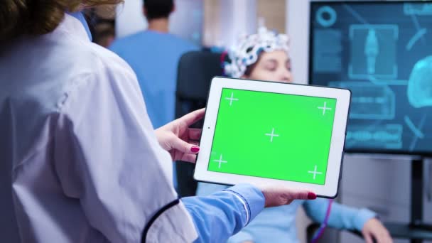 Vrouwelijke arts kijkt naar tablet groen scherm in een moderne faciliteit voor neurologie wetenschap — Stockvideo