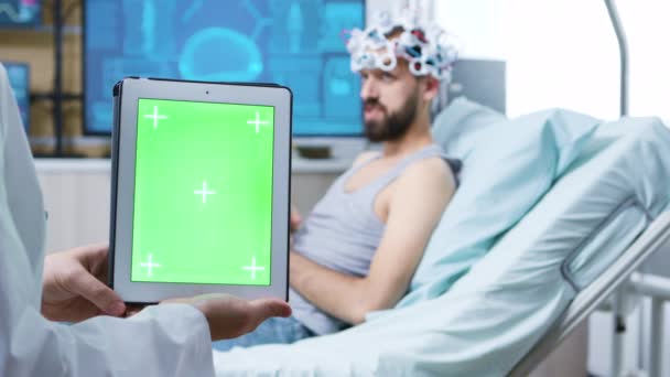 Médico en una clínica de neurología sosteniendo tableta con pantalla verde — Vídeos de Stock