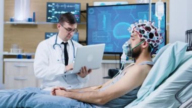 Modern bir tesiste beyin analizi için laptopunu kullanan bir doktor.