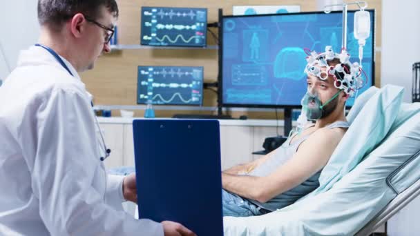 Patient in einem neurowissenschaftlichen Zentrum mit Gehirnwellen-Scanning-Headset und Luftmaske — Stockvideo