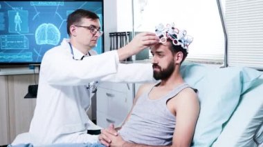 Nöroloji merkezinde bir doktor beyin analizi için hastayı hazırlıyor.