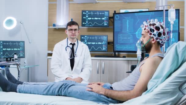 Doctor sentado en la silla en las instalaciones modernas de investigación del cerebro y haciendo gestos de la mano — Vídeos de Stock