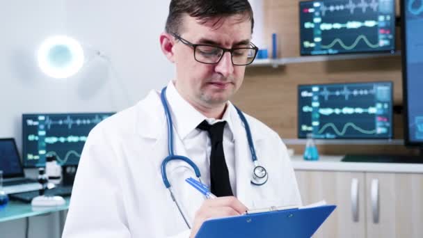 Doctor in neuroscience centre writing notes on clipboard — Stock Video