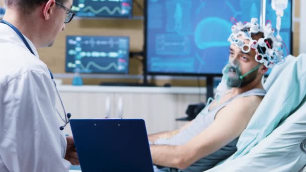 Patiënt met hersenletsel op een klembord in een neurologisch onderzoekscentrum — Stockvideo