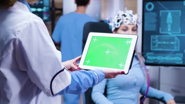 Женщина-врач держит планшет с зеленым экраном в современной неврологической лаборатории — стоковое видео