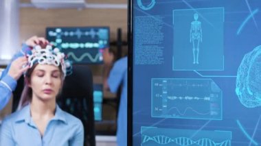 Nöroloji biliminde kadın doktor hasta kulaklığı üzerinde değişiklikler yapıyor.