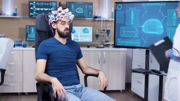 Patient avec un casque à balayage d'ondes cérébrales fermant les yeux — Video
