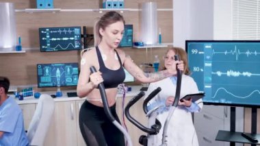 Spor biliminde bayan doktor, bayan sporcunun kalp atışlarını test ediyor.