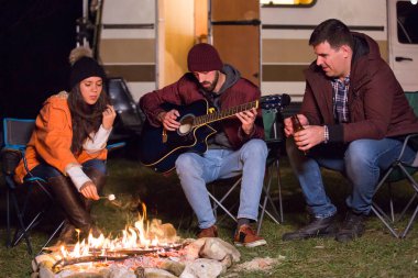 Kafkasyalı kız kamp ateşinde lokum pişiriyor.
