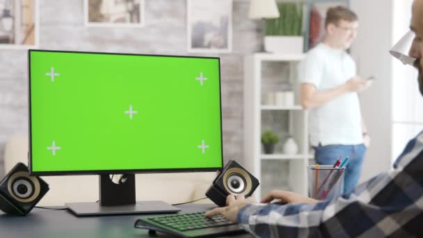 Parallax inzoomen shot van de mens op zoek naar groene scherm geïsoleerde mock-up Pc display — Stockvideo