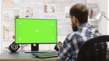 Parlak oturma odasında yeşil ekranda çalışan adamın statik görüntüsü.