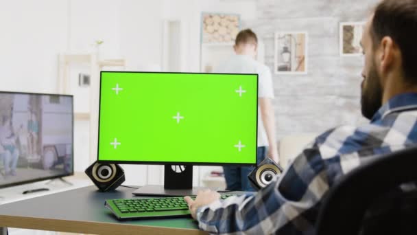 Inzoomen shot van de mens typen op groen scherm Pc — Stockvideo