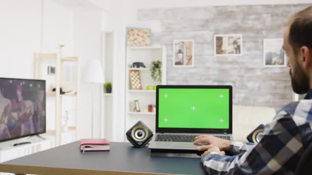 Man surfen op het internet op groene scherm laptop in helder en zeer goed verlichte flat — Stockvideo