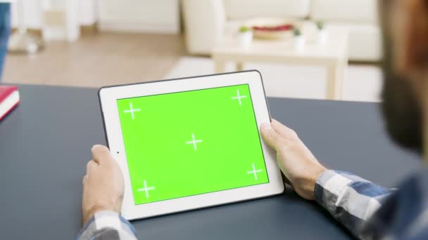 Sobre el hombro de un hombre sosteniendo una tableta con pantalla verde — Vídeo de stock