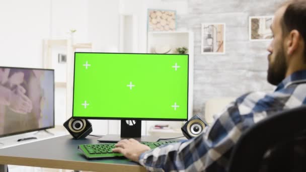 Inzoomen shot van de man die werkt op groen scherm Pc — Stockvideo
