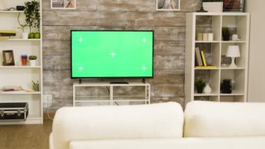 Büyük yeşil ekran televizyon. Parlak ve iyi aydınlatılmış oturma odasında kimse yok.
