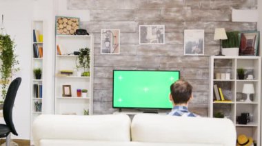 TV 'de spor izleyen genç adamın arka planı