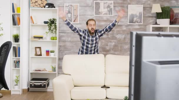 Eccitato giovane uomo mentre guarda lo sport in televisione — Video Stock