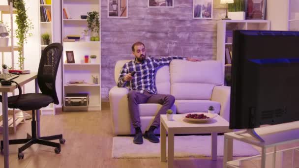 Bearded man with serious face using remote control — Stock Video