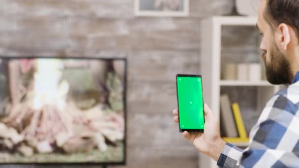 Вид сзади бородатый мужчина держит телефон с зеленым экраном — стоковое видео