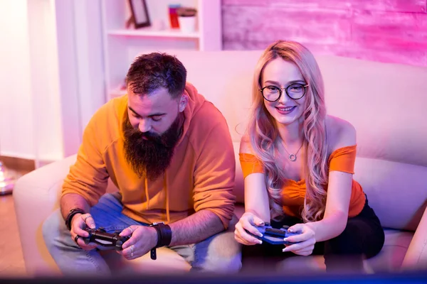 Весела молода пара сидить на дивані і грає у відеоігри — стокове фото