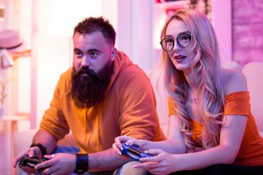 Çift kanepede oturuyor ve online video oyunları oynuyor.