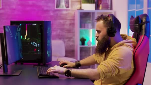 Jogador de jogo profissional usando fones de ouvido em uma sala com néons coloridos — Vídeo de Stock