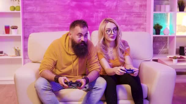 Jugadora femenina jugando videojuegos en línea con su novio — Vídeo de stock