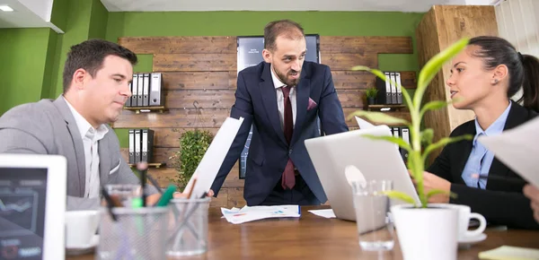Kaukasischer Geschäftsmann im Anzug diskutiert mit seinem Team — Stockfoto