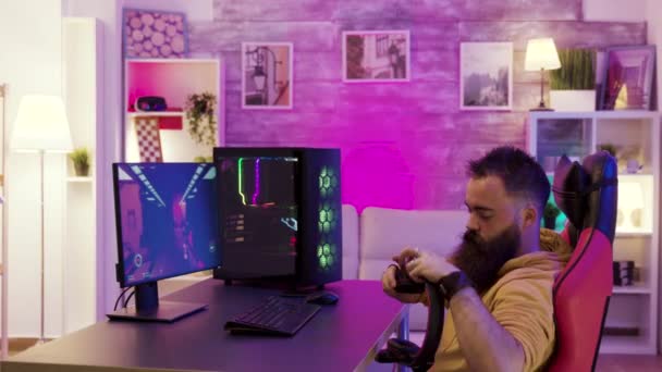 Bearded young man putting his headphones while playing video games on pc — Stock Video