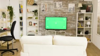 Parlak ve aydınlık oturma odasında yeşil ekran televizyon.