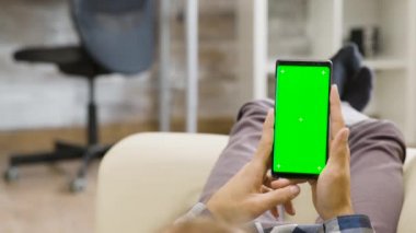 Parallaks görüntüsü, elinde yeşil ekran bir telefon tutan bir adam.