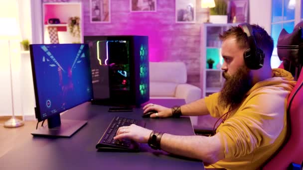 Успешный человек расслабляется, играя в онлайн игры в своей комнате — стоковое видео