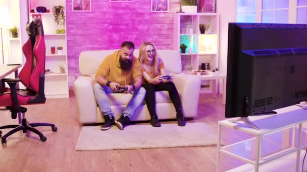 Novio barbudo jugando juegos en línea con su hermosa novia rubia — Vídeo de stock